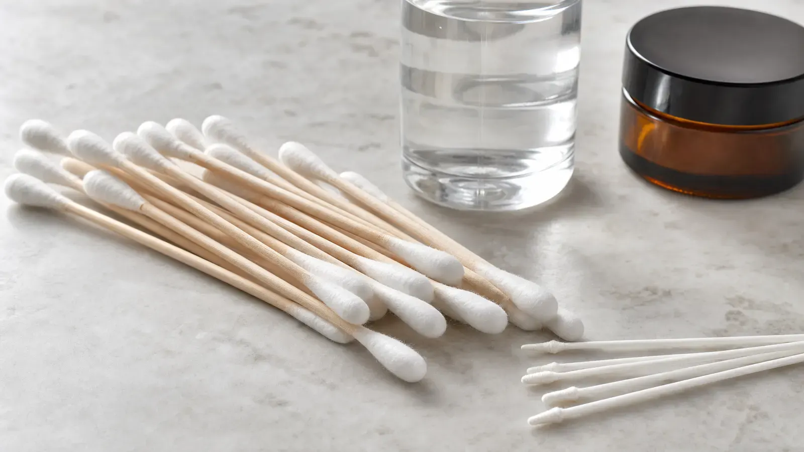 Clean cotton swabs arranged with iso bottle and closed amber jar